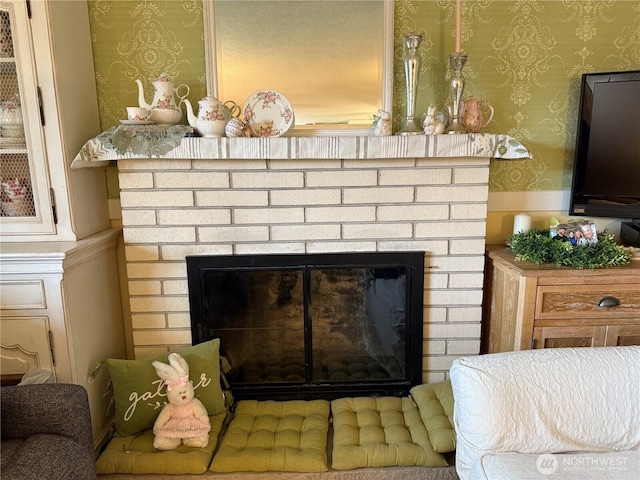 details with wallpapered walls and a brick fireplace