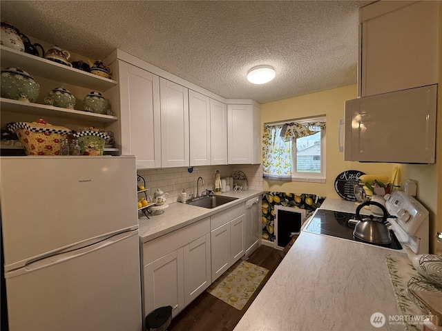 kitchen featuring white appliances, white cabinets, and dark wood-style flooring