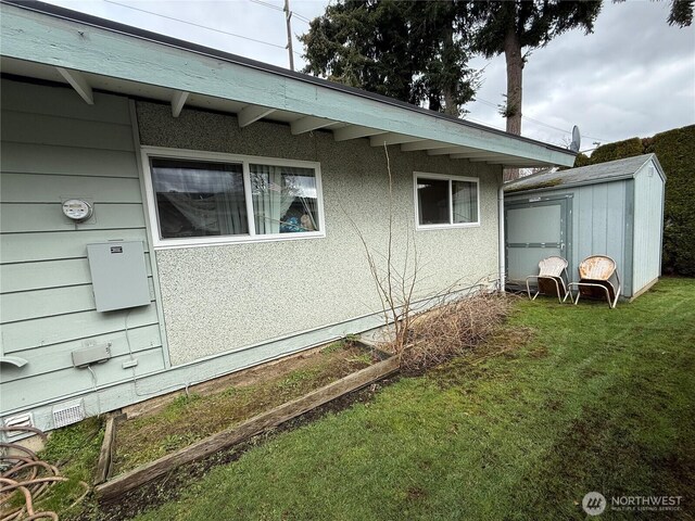 view of side of property with a storage shed, an outbuilding, and a lawn