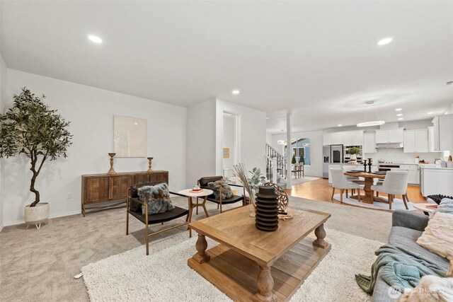 living room with light carpet, recessed lighting, stairs, and baseboards