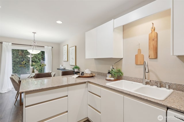 kitchen featuring pendant lighting, a sink, white cabinetry, recessed lighting, and a peninsula