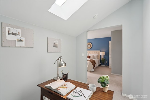 carpeted office featuring baseboards and vaulted ceiling with skylight