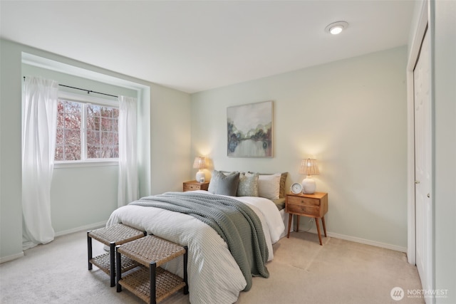 bedroom featuring light colored carpet and baseboards