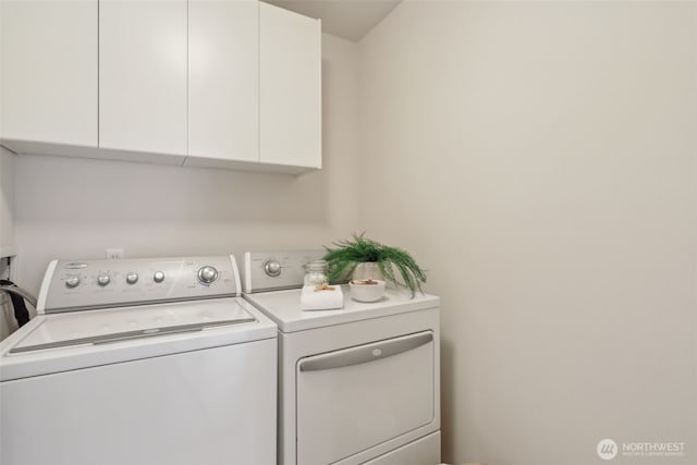 laundry room with washing machine and clothes dryer and cabinet space