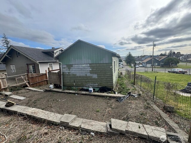 view of side of property with a lawn and fence