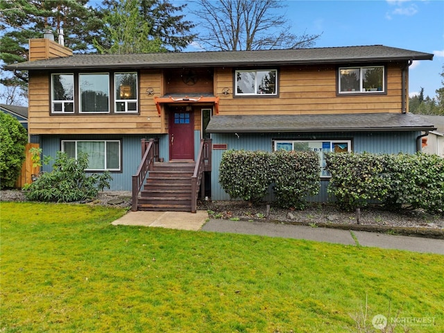 split foyer home with a front lawn and a chimney