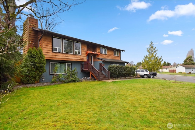 raised ranch featuring a front yard and a chimney