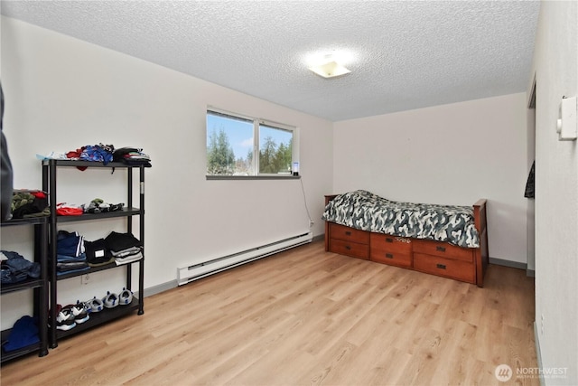 bedroom with a textured ceiling, wood finished floors, and a baseboard radiator