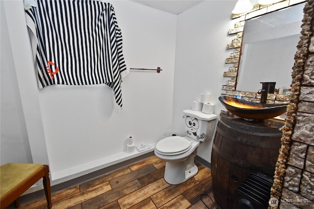 bathroom with vanity, toilet, baseboards, and wood-type flooring