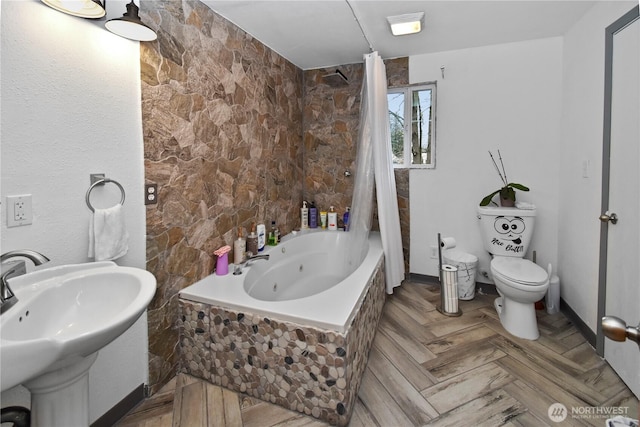 full bath featuring a sink, toilet, and a combined bath / shower with jetted tub