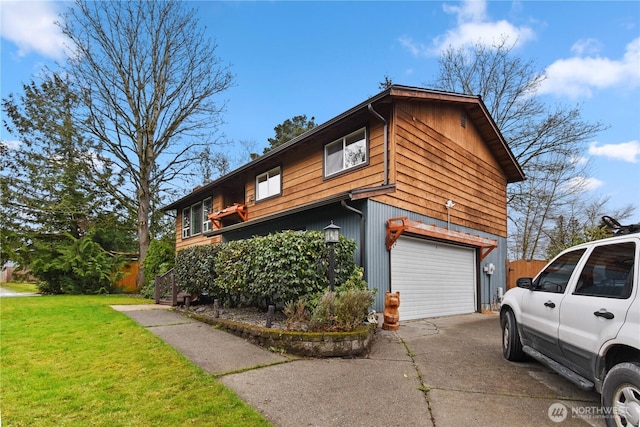 view of side of home with a garage, a yard, and concrete driveway