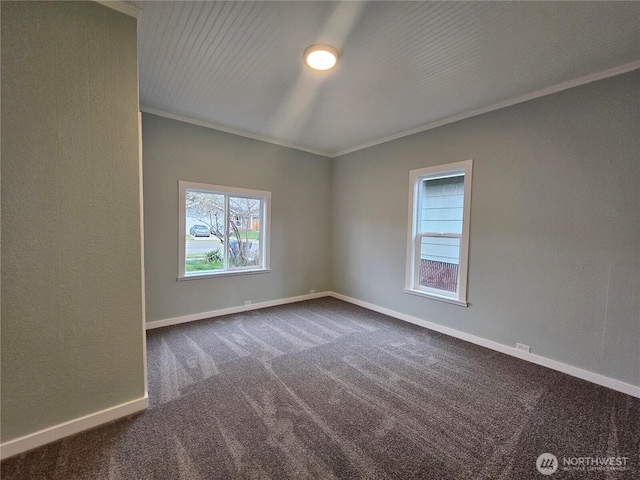 empty room with crown molding, baseboards, and dark carpet