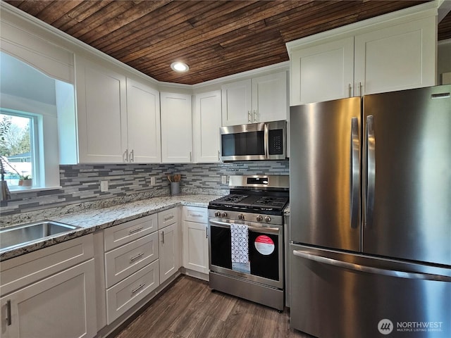 kitchen with decorative backsplash, appliances with stainless steel finishes, wooden ceiling, and white cabinets