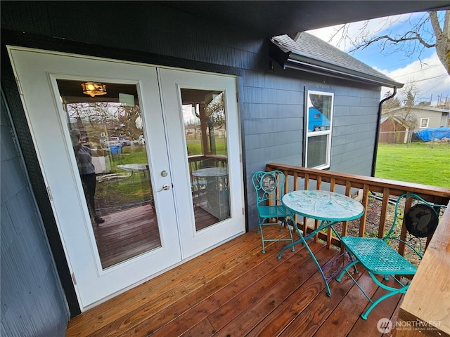 wooden terrace featuring french doors and a yard