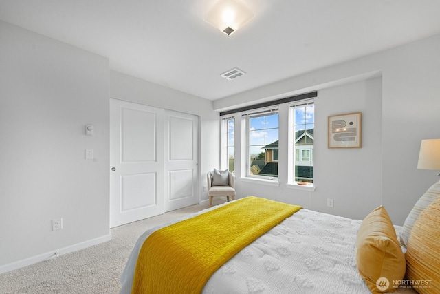 bedroom with carpet, visible vents, a closet, and baseboards