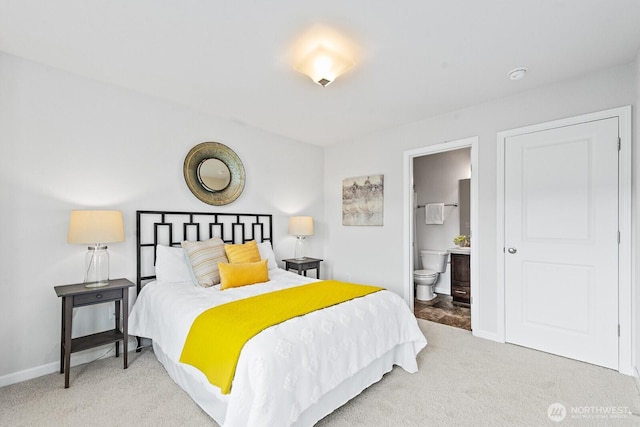 carpeted bedroom with baseboards and ensuite bath