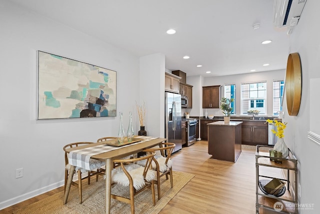 dining room featuring recessed lighting, baseboards, light wood finished floors, and a wall mounted AC