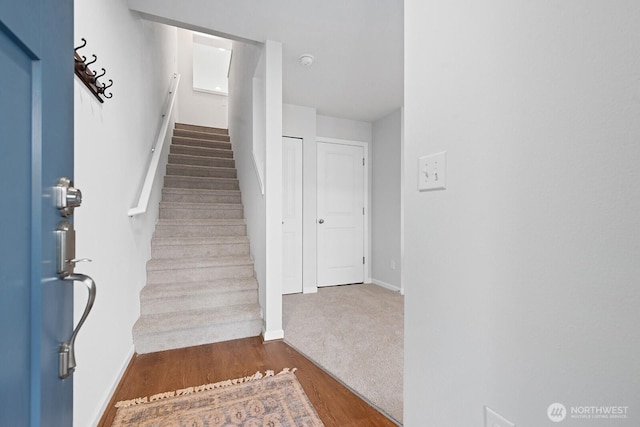 stairs with wood finished floors and baseboards