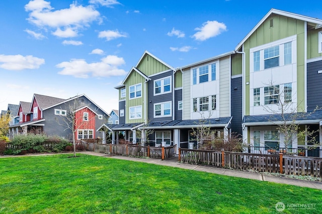 view of front of home with a front yard, board and batten siding, and a residential view