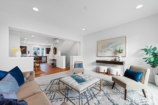 living area featuring recessed lighting, a wall mounted AC, baseboards, and wood finished floors