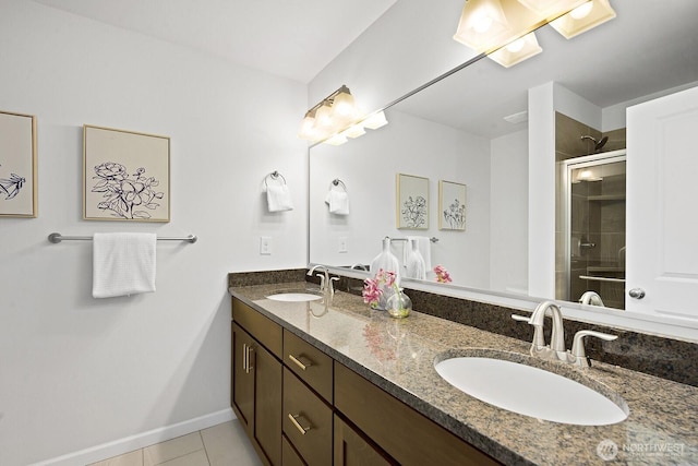 bathroom with double vanity, a shower stall, tile patterned floors, and a sink