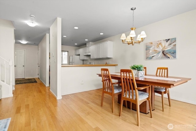 dining room with light wood-type flooring, recessed lighting, baseboards, and a chandelier
