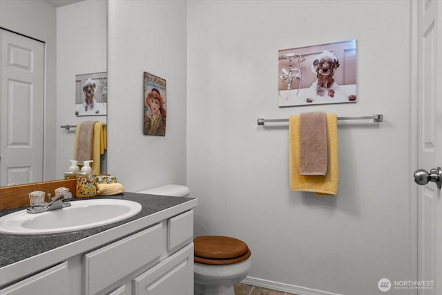 half bath featuring vanity and toilet