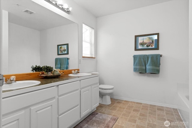 bathroom featuring double vanity, toilet, visible vents, and a sink
