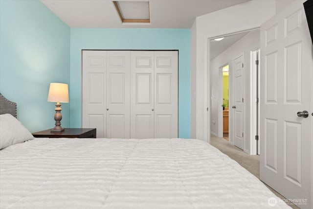carpeted bedroom featuring a closet and attic access