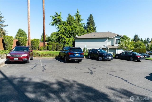 uncovered parking lot featuring fence