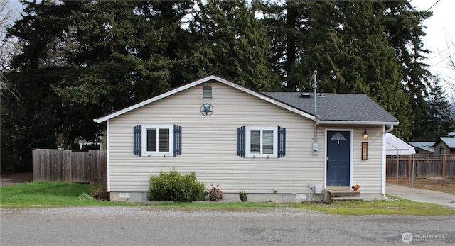 bungalow with crawl space, a shingled roof, and fence