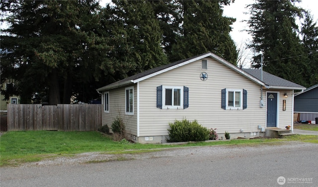 view of front of home with fence and crawl space