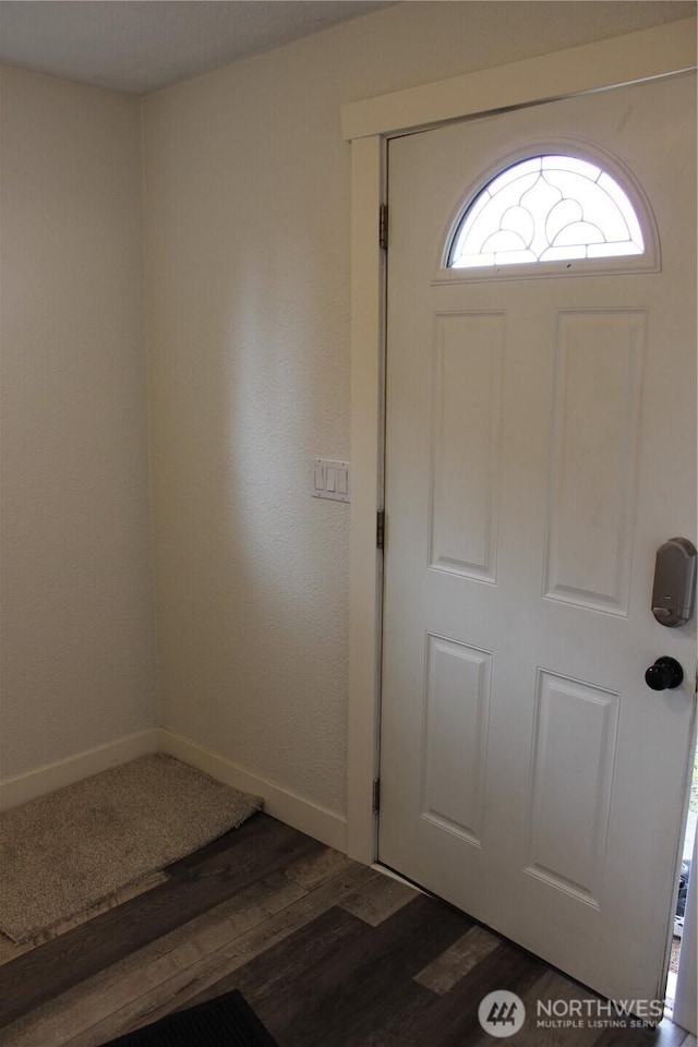 foyer with baseboards and wood finished floors