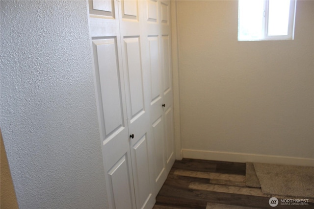 corridor with baseboards and dark wood-style floors