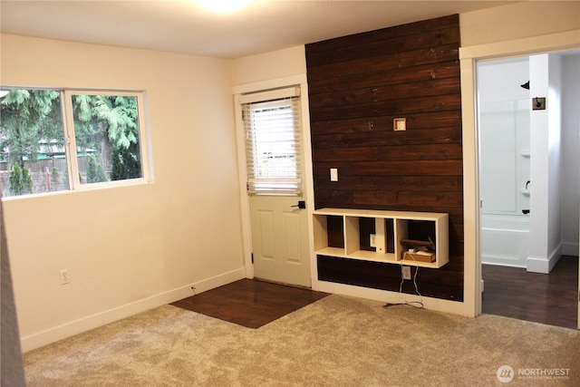 foyer entrance with baseboards and carpet