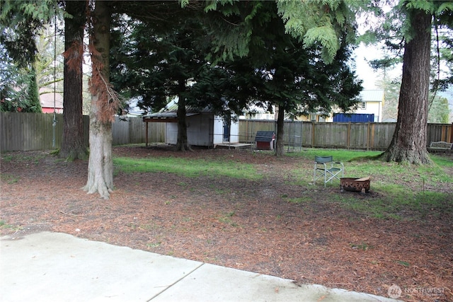 view of yard featuring a fenced backyard and a fire pit