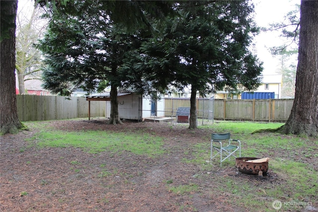 view of yard with a fenced backyard and an outdoor fire pit