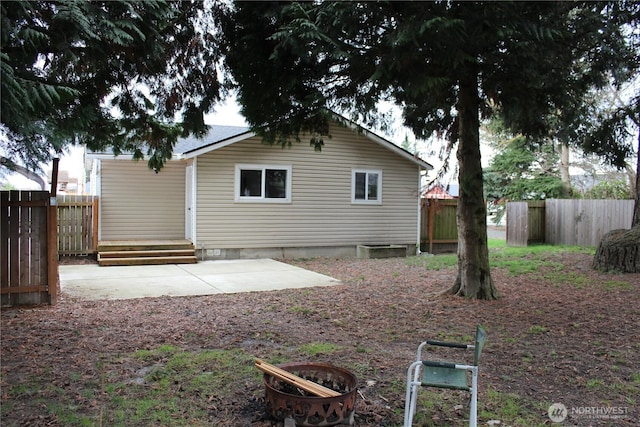 rear view of property featuring a patio and fence