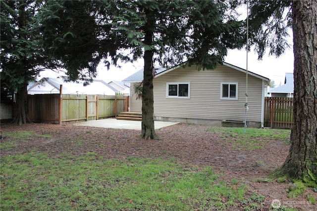 back of property with a fenced backyard and a patio area