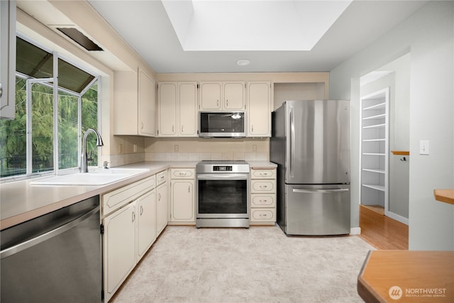 315 Point Fosdick Pl NW, Gig Harbor, WA 98335 - kitchen with a sink, stainless steel appliances, a tray ceiling, and light countertops
