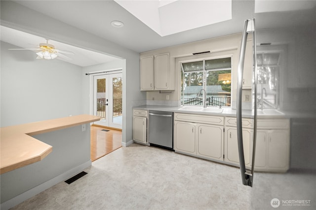 315 Point Fosdick Pl NW, Gig Harbor, WA 98335 - kitchen featuring dishwasher, light countertops, a skylight, and a sink