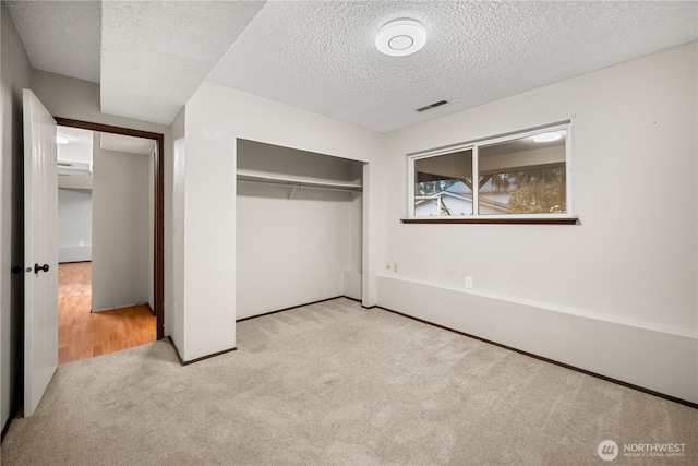 315 Point Fosdick Pl NW, Gig Harbor, WA 98335 - unfurnished bedroom featuring a closet, visible vents, a textured ceiling, and carpet