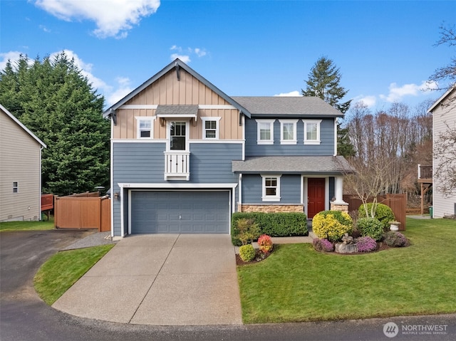 craftsman inspired home with fence, an attached garage, concrete driveway, a front lawn, and board and batten siding