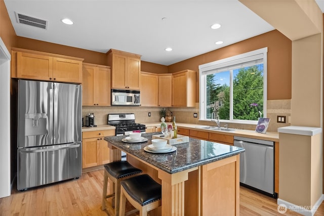 kitchen featuring a sink, visible vents, light brown cabinetry, and stainless steel appliances