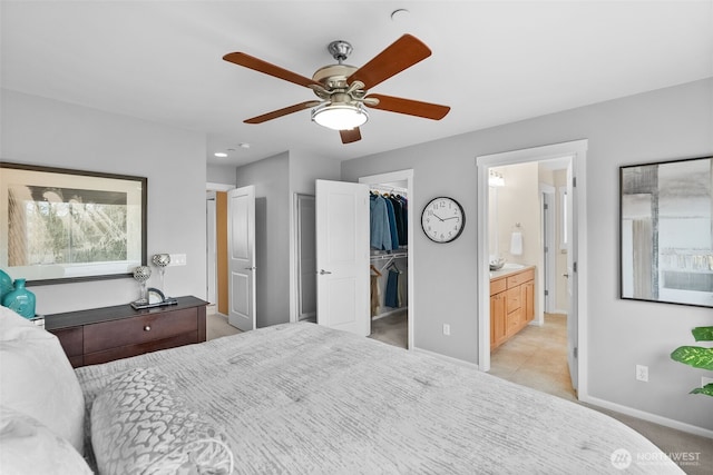 bedroom featuring a spacious closet, light colored carpet, baseboards, and a closet