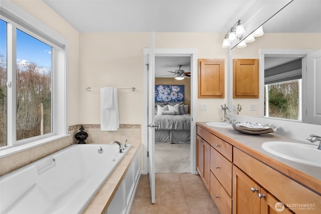 full bathroom with a wealth of natural light, tile patterned floors, ensuite bath, and a sink