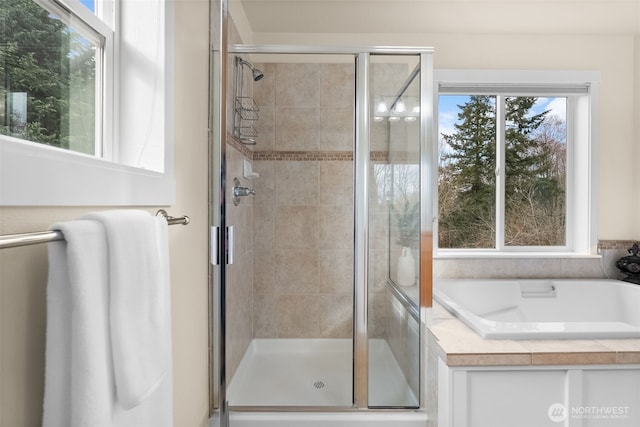 bathroom featuring a bath and a stall shower