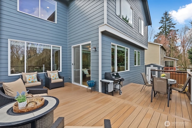 wooden deck featuring outdoor dining space and area for grilling