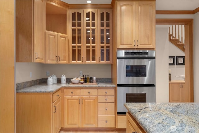 kitchen featuring double oven, glass insert cabinets, and light brown cabinetry