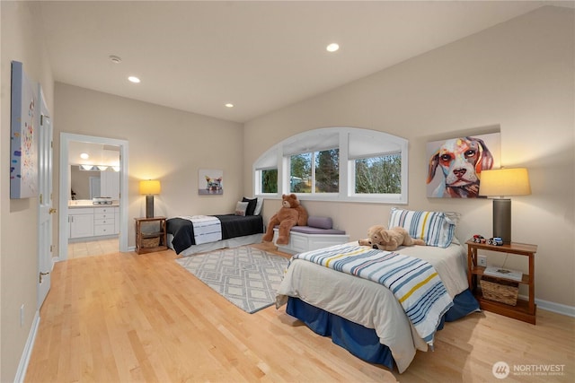 bedroom with recessed lighting, connected bathroom, baseboards, and wood finished floors